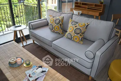 Stylish living room with modern sofa and balcony view, perfect for relaxation.