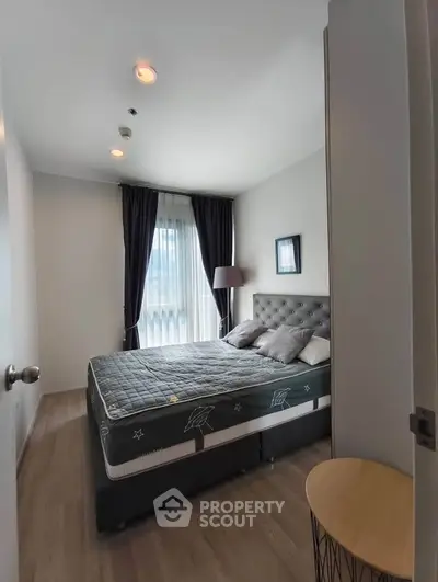 Cozy bedroom with stylish decor and natural light, perfect for relaxation.