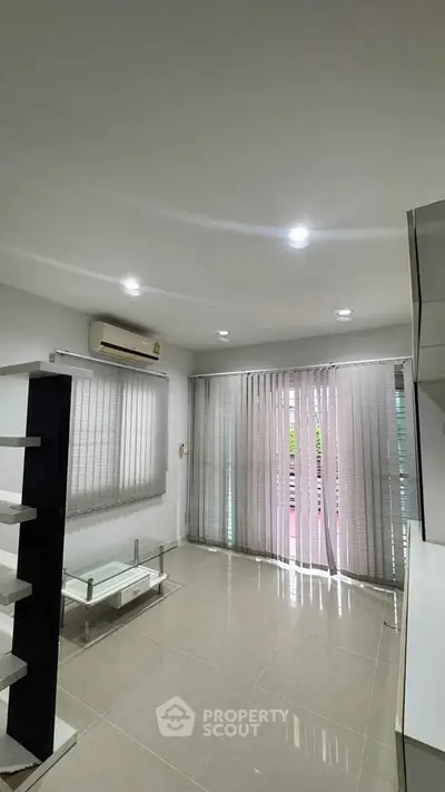Modern living room with sleek design, air conditioning, and large windows for natural light.
