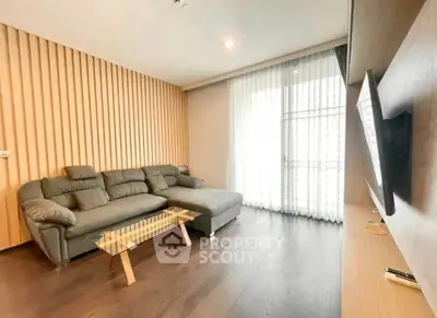 Modern living room with sleek sofa and large window, perfect for relaxation and entertainment.