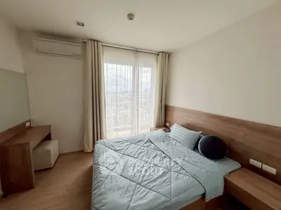 Modern bedroom with large window and city view, featuring minimalist design and cozy atmosphere.