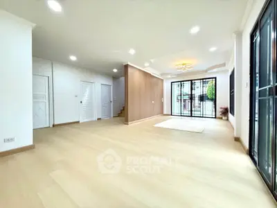 Spacious modern living room with large windows and wooden flooring