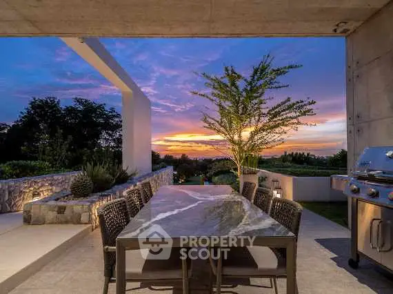 Stunning outdoor dining area with sunset view and modern grill.