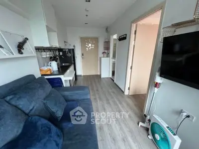 Cozy living room with modern decor and open kitchen layout in a compact apartment.