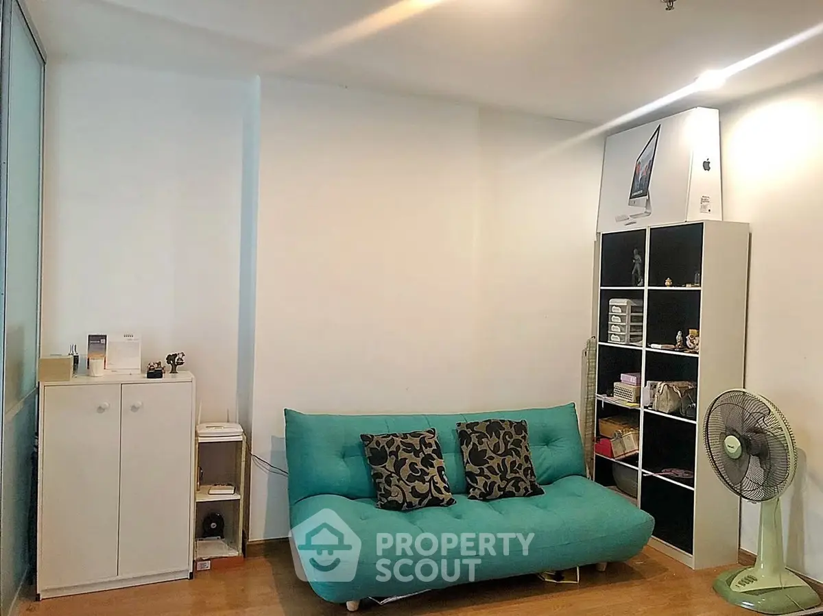 Cozy living room with teal sofa and modern shelving unit