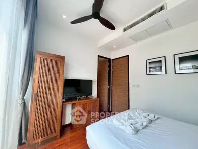 Modern bedroom with wooden furniture and ceiling fan, featuring a cozy atmosphere.