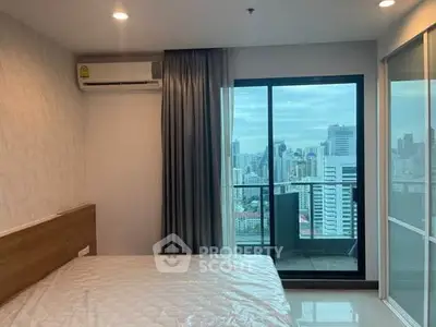Modern bedroom with city view and balcony access in high-rise apartment