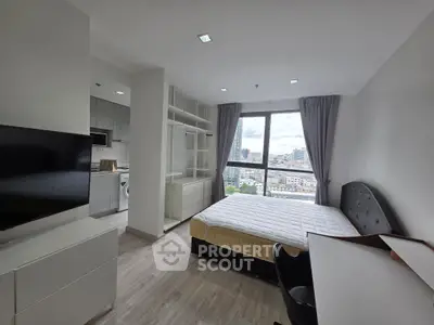 Modern bedroom with city view, featuring sleek furniture and large windows for natural light.