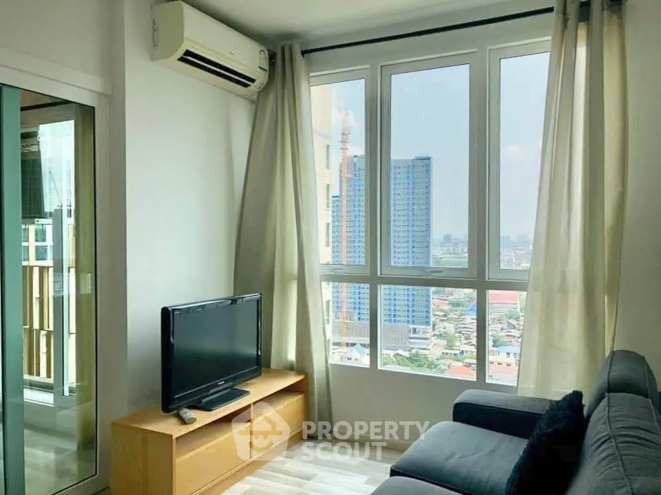 Modern living room with large windows offering stunning city views in a high-rise apartment.