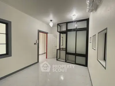 Spacious modern interior with sleek glass partition and elegant lighting, perfect for versatile living space.