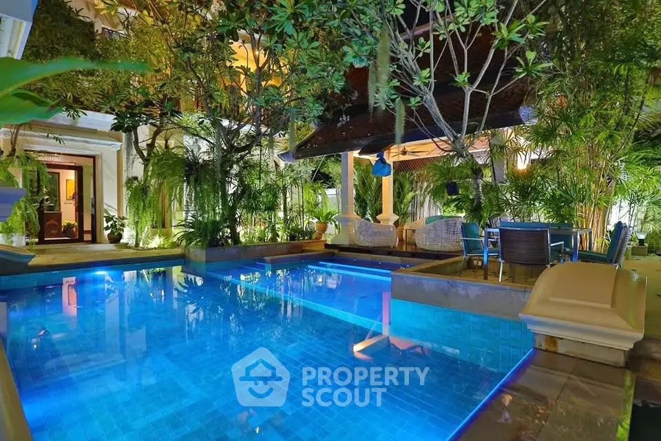 Luxurious outdoor pool area with lush greenery and elegant seating, perfect for relaxation and entertainment.