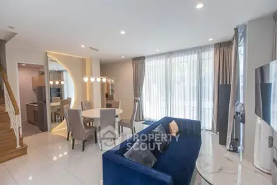 Modern living room with elegant dining area and stylish blue sofa