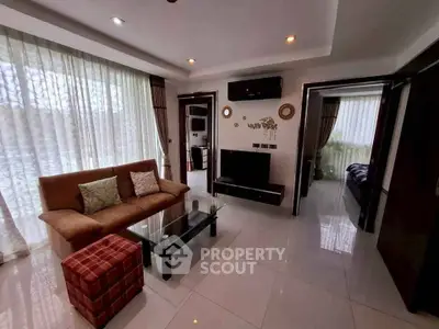 Elegant living room with modern decor and natural light, featuring a cozy sofa and stylish glass coffee table.