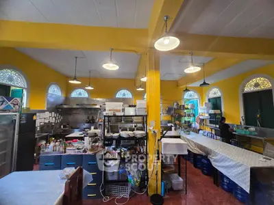 Spacious commercial kitchen with vibrant yellow walls and modern appliances, ideal for culinary businesses.