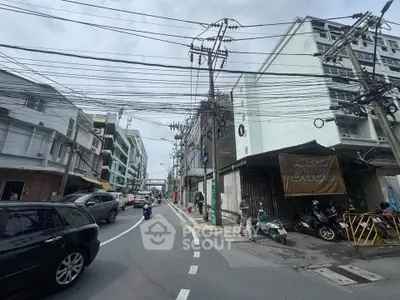 Urban street view with buildings and parked vehicles, showcasing city life and infrastructure.