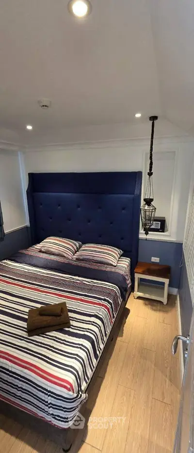 Cozy bedroom with stylish blue headboard and modern lighting