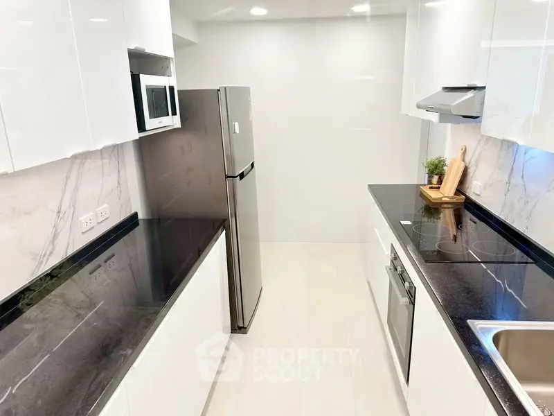 Modern kitchen with sleek black countertops and stainless steel appliances