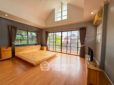 Spacious bedroom with large windows and balcony offering scenic views, perfect for relaxation and comfort.