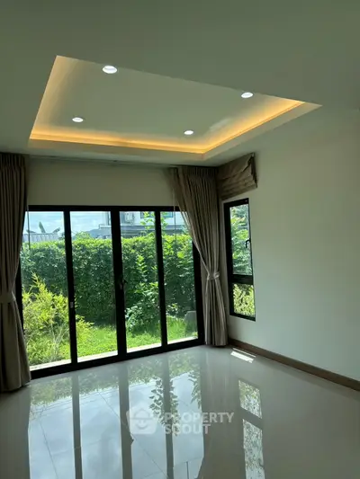 Spacious modern living room with large windows and garden view