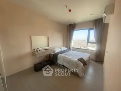 Spacious bedroom with large window offering stunning city views, modern decor, and ample natural light.