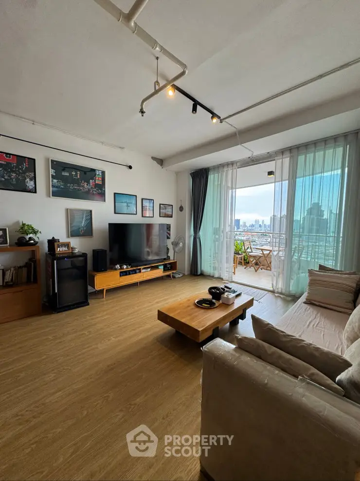 Spacious living room with modern decor and city view balcony, perfect for urban living.