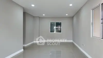 Spacious empty room with tiled flooring and large window, perfect for customization.