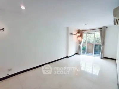 Spacious living room with large windows and garden view, perfect for natural light lovers.