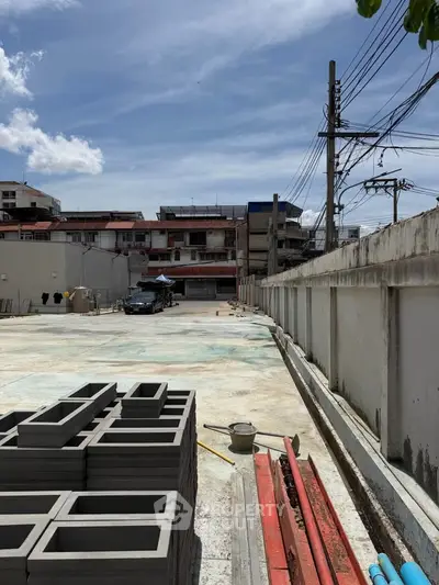 Construction site with concrete blocks and urban backdrop under clear sky