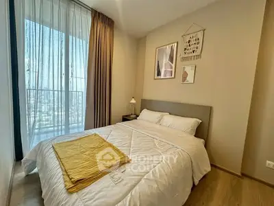 Cozy bedroom with large window and modern decor, offering a bright and inviting atmosphere.