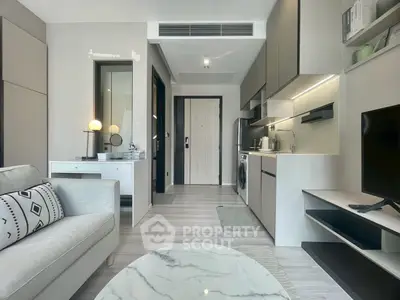 Modern apartment interior with sleek kitchen and cozy living area, featuring stylish decor and natural light.