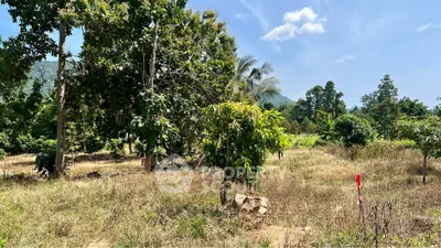 Scenic land plot with lush greenery and mountain backdrop, perfect for development or investment.
