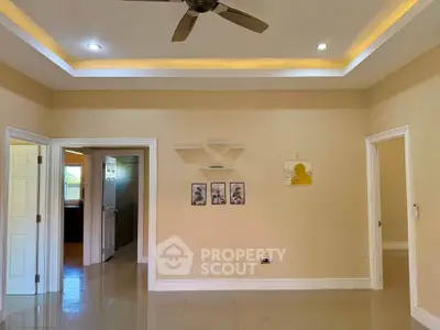 Spacious living room with modern ceiling fan and recessed lighting, ideal for family gatherings.