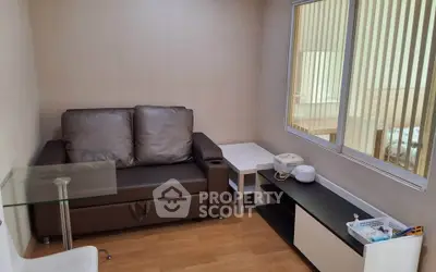 Cozy living room with brown leather sofa and modern glass table