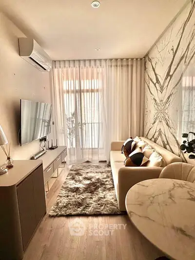 Luxurious living room with modern decor and marble accents, featuring a cozy sofa and stylish TV setup.