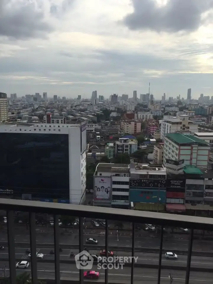 Stunning cityscape view from high-rise balcony overlooking urban skyline and bustling streets.