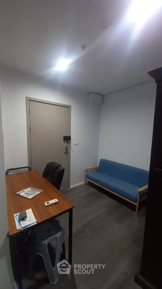 Cozy small living room with blue sofa and wooden table, ideal for compact apartments.