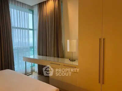 Modern bedroom with large window and elegant curtains, featuring a sleek built-in desk and wardrobe.