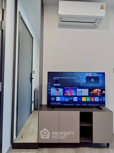 Modern living room with sleek TV unit and air conditioning, perfect for cozy entertainment.