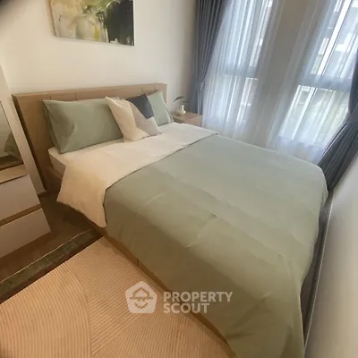 Cozy bedroom with modern decor and natural light from large windows.