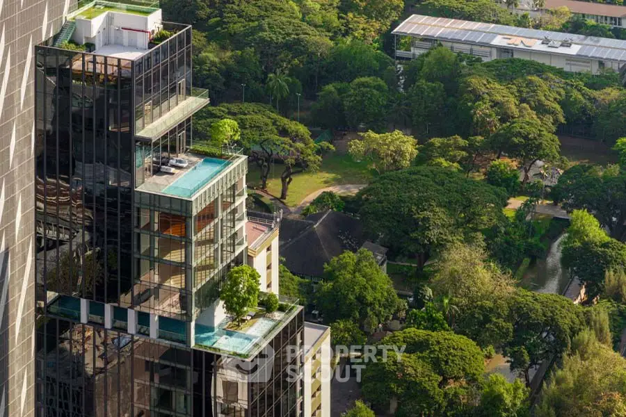 Luxurious high-rise building with rooftop pool and lush green surroundings.