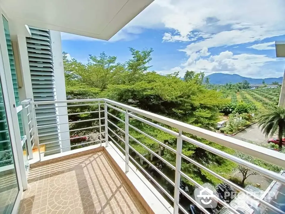 Spacious balcony with stunning mountain and garden views, perfect for relaxation and enjoying nature.