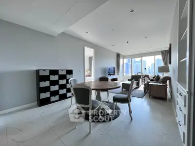 Spacious modern living room with city view, elegant furniture, and ample natural light.