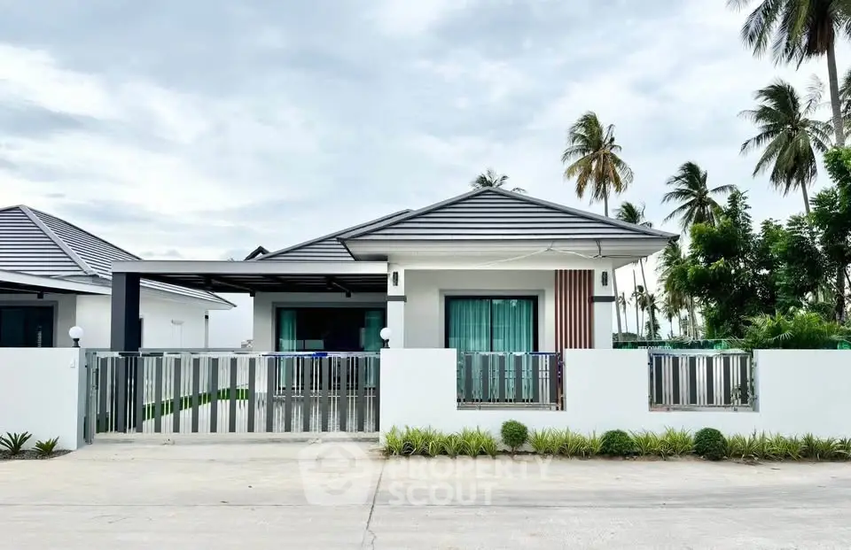 Charming modern bungalow with sleek design and lush palm trees in a serene neighborhood.