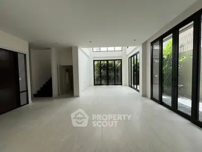 Spacious modern living room with large windows and natural light