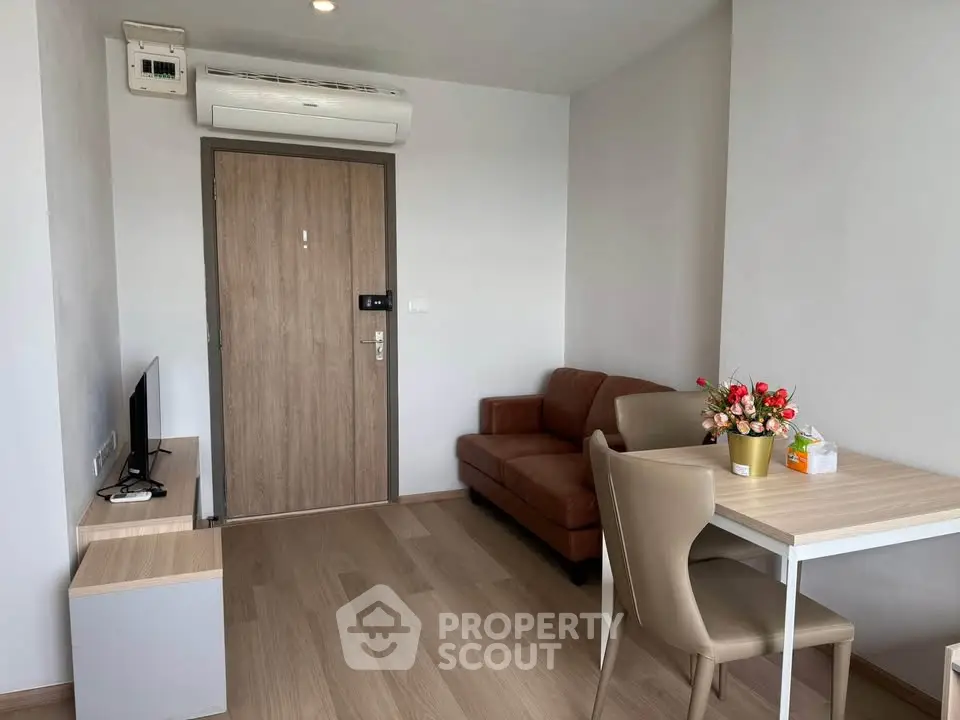 Modern living room with sleek furniture and wooden flooring, featuring a cozy sofa and dining area.