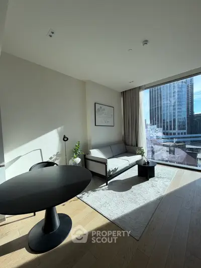 Modern living room with large window offering stunning city view, stylish furniture, and natural light.
