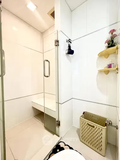 Modern bathroom with glass shower enclosure and sleek white tiles