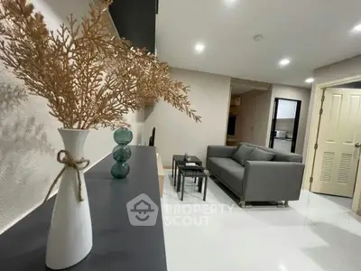 Modern living room with sleek gray sofa and stylish decor, perfect for relaxation and entertaining.