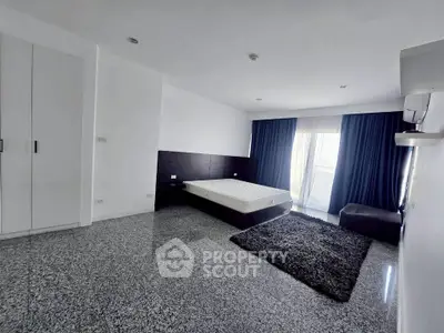 Spacious modern bedroom with sleek design and large window for natural light.