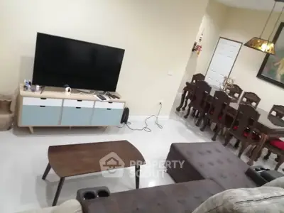 Spacious living room with modern furniture and dining area, perfect for family gatherings.